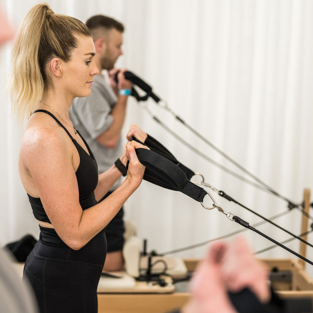 Reformer Pilates lifestyle image hands in straps