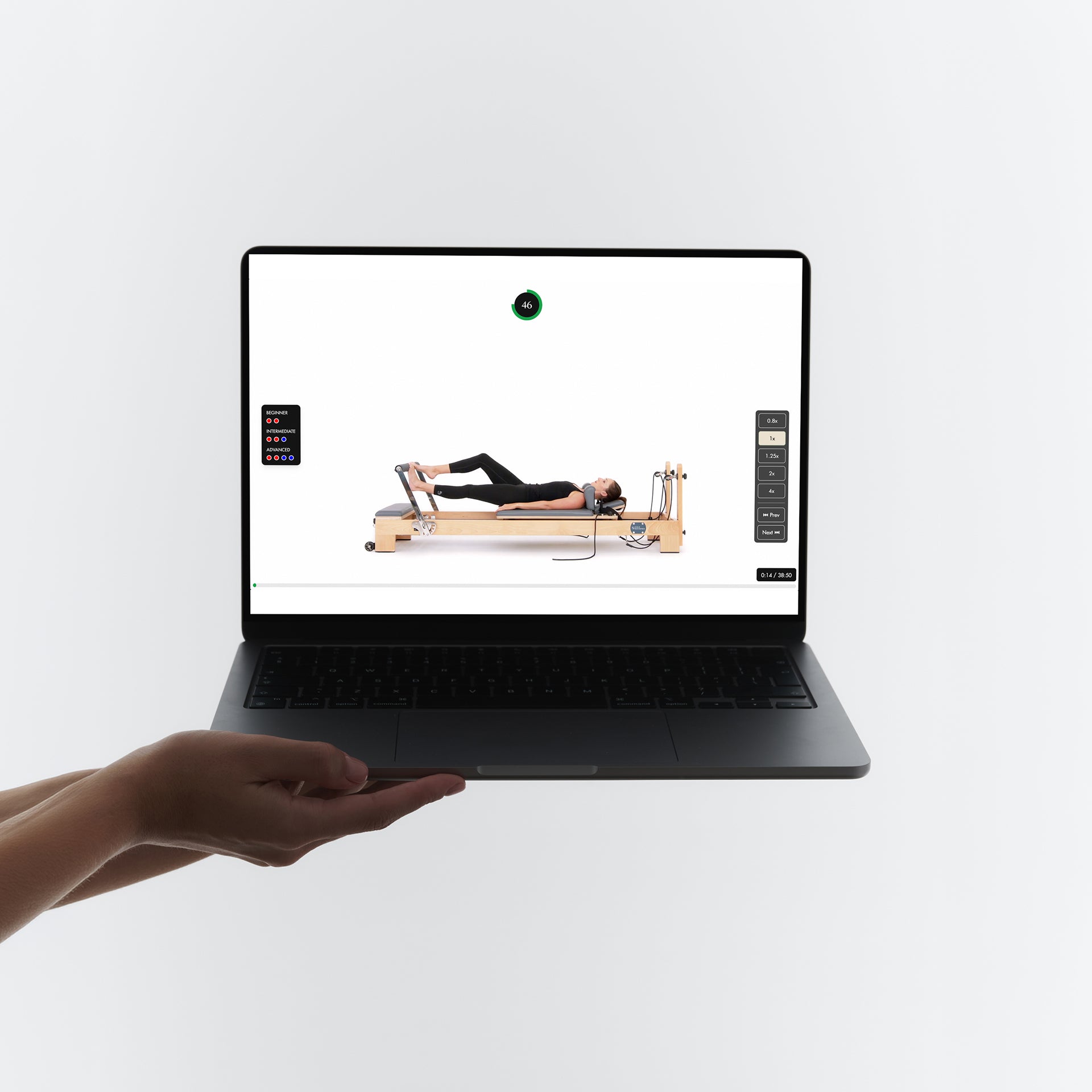 InstructorPro exercise video on laptop showing reformer Pilates class with spring resistance levels | Your Reformer