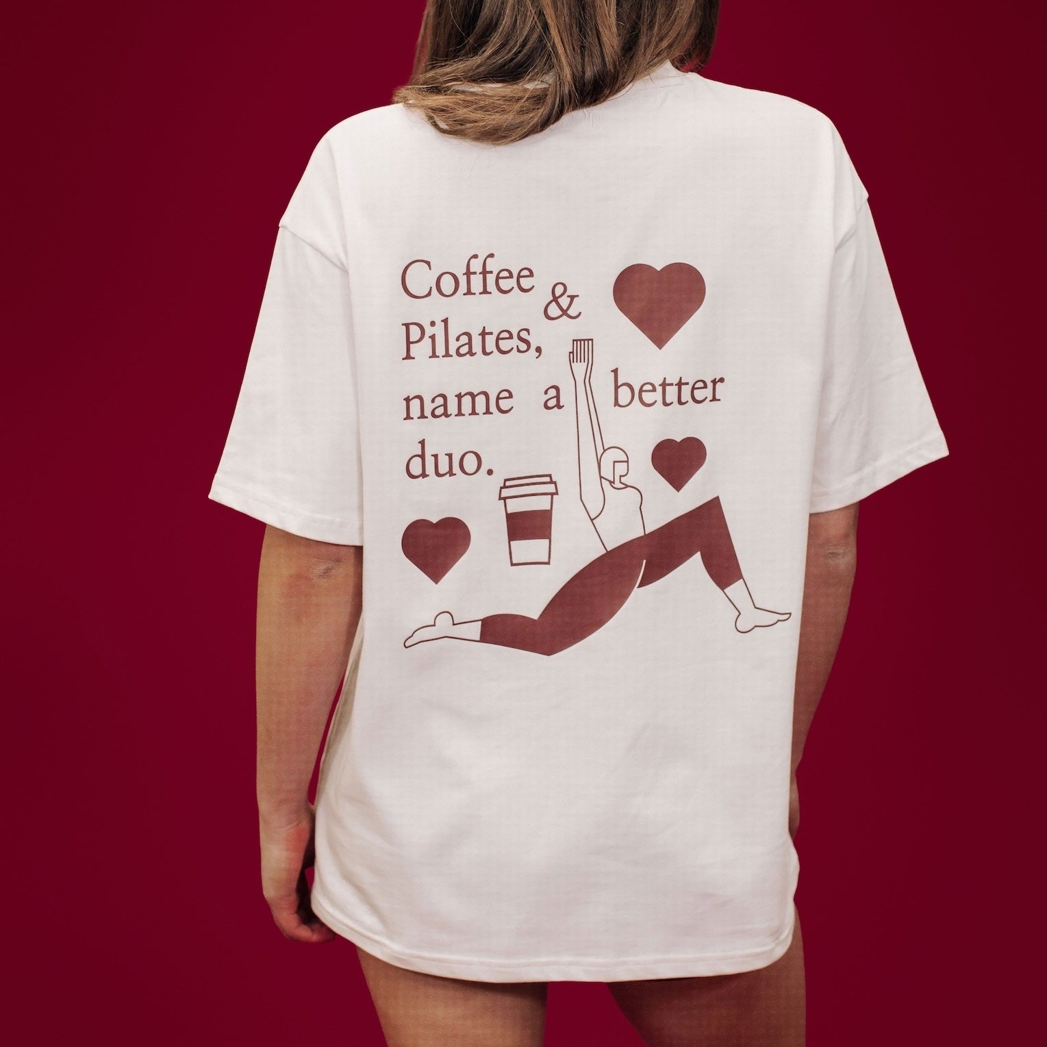 Person wearing a white t-shirt with text and graphics on the back against a red background